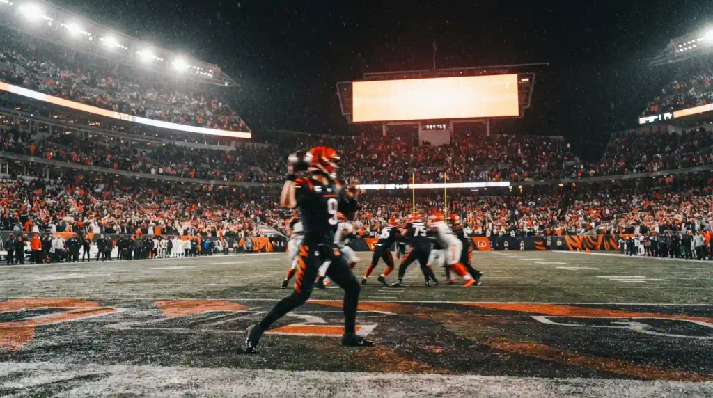 Quarterback dropping back in a packed stadium at night, representing Joe Burrow's 2026 season quotes.
